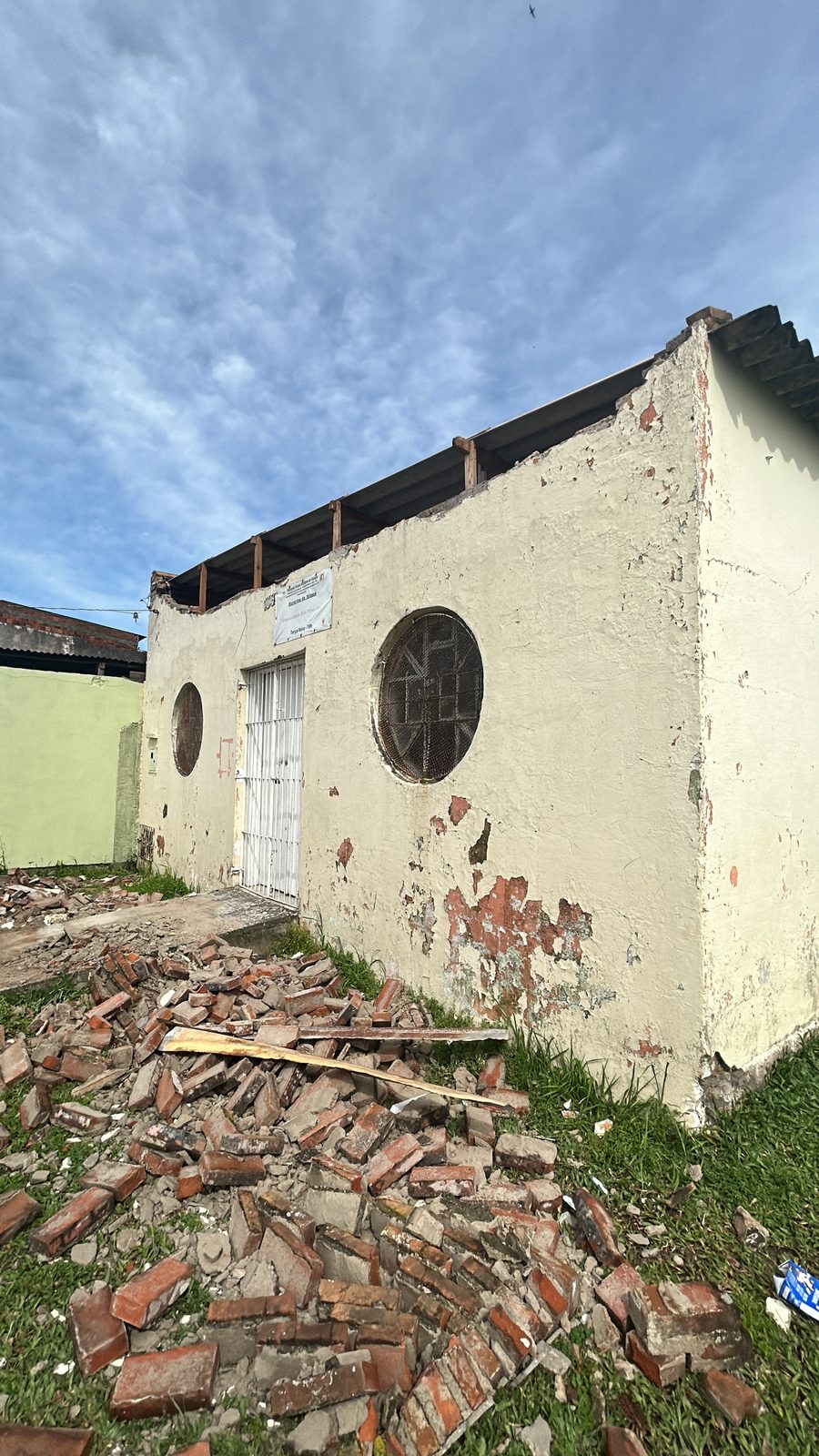Lateral externa da Capela São Francisco de Assis, com telhas e tijolos quebrados no chão
